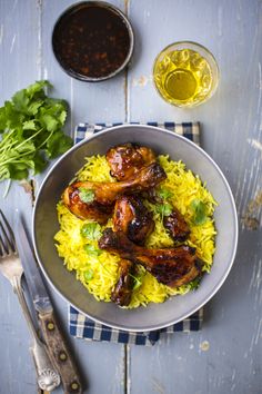 a bowl filled with yellow rice and chicken wings