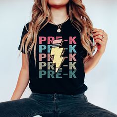 a woman sitting on the ground wearing a t - shirt that says pre k, pinkk, break