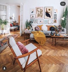 a living room filled with furniture and pictures on the wall