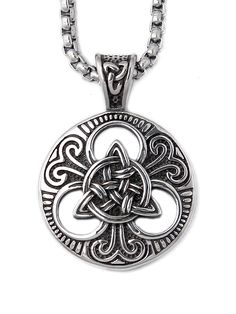 a silver pendant with an intricate design on it