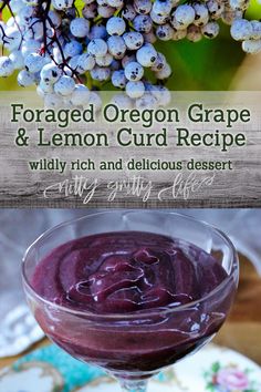 a glass filled with blueberry sauce on top of a wooden table next to grapes