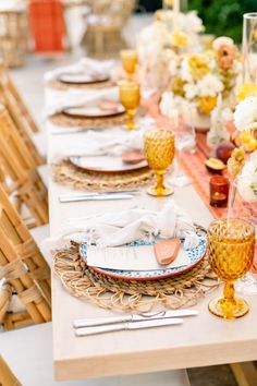 the table is set with plates and place settings