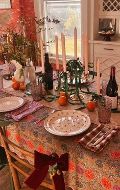 a dining room table is set with candles and plates