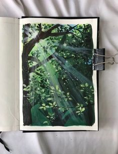 an open book with a drawing of trees and sunlight coming through the leaves on it