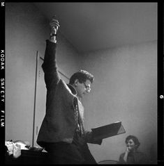 a black and white photo of a man holding a book