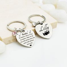 two heart shaped keychains with names on them