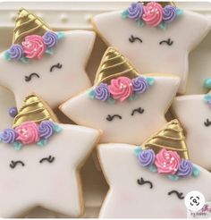 decorated cookies with unicorn faces and flowers on them are sitting in a white tray together