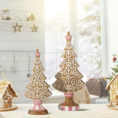 three wooden christmas trees on a table in front of a window