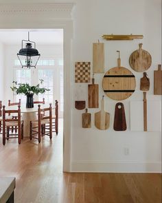 a kitchen with wooden utensils hanging on the wall and wood flooring in front of it