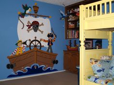 a child's bedroom decorated in blue and yellow with pirate themed wall decals