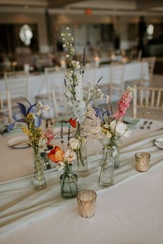 several vases with flowers are sitting on a table