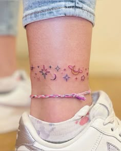 a woman's ankle with stars and planets on the left side of her leg