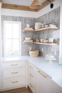 a kitchen with white cabinets and open shelves