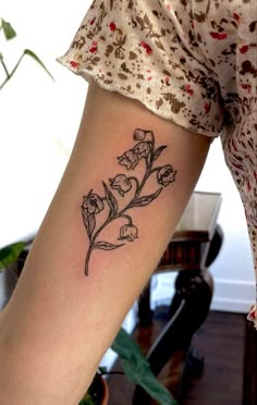 a woman's arm with a flower tattoo on the left side of her body