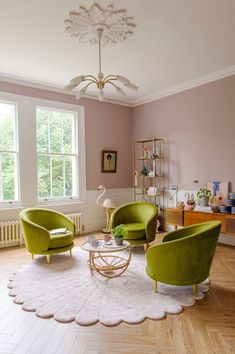 a living room with two green chairs and a white rug