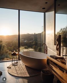 a large bath tub sitting in the middle of a bathroom next to a tall window