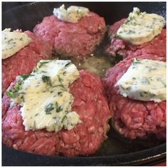 several hamburger patties are being cooked in a skillet on the stove top with cheese and herbs