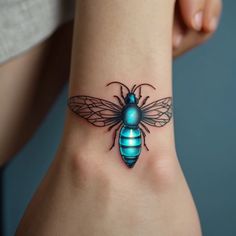 a blue and black bee tattoo on the right side of the wrist, it's wings spread out