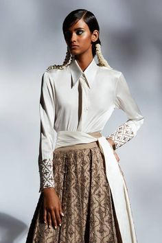 Ivory satin shirt with straight collar, Mughal motifs, contrast metallic cut dana and zari embroidered sleeve cuffs.
Components: 1
Pattern: Embroidered
Type Of Work: Cut Dana and Zari Work
Neckline: Straight Collar
Sleeve Type: Full Cuff Sleeves
Fabric: Satin
Color: Ivory
Other Details: 
Broad sleeve cuffs
Closure: Front concealed hook and eye
Note: The belt, lehenga and hair accessory worn by the model is not for sale
Occasion: Party,Cocktail - Aza Fashions Belt Lehenga, Mughal Motifs, Shirt Cuff, Zari Work, Satin Color, Satin Shirt, Shirt For Women, Color Ivory, Cuff Sleeves