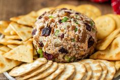 a cheese ball on top of crackers with fruit and vegetables around it, ready to be eaten