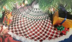 an ornament hanging from the top of a christmas tree with presents on it