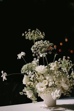 a vase filled with white flowers on top of a table