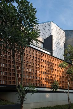 the building is made out of wood and has many windows on each side, along with several trees