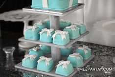 a tiered cake with blue and white cakes on it's sides, decorated with bowknots