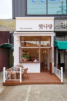 the outside of a cafe and dessert shop with tables and chairs in front of it