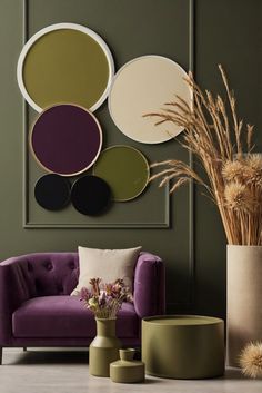 a living room with green walls and purple furniture in the center, along with round mirrors on the wall