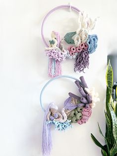 three crocheted hair ties with tassels on them next to a potted plant