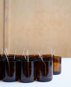 six brown glass jars with pins stuck in them