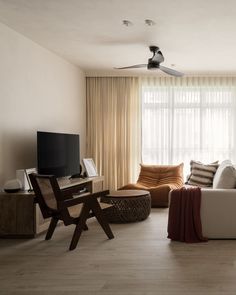 a living room filled with furniture and a flat screen tv on top of a wooden stand