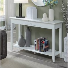 a white table with a mirror and lamp on it