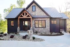 a stone house with a metal roof and two windows on the front door is shown