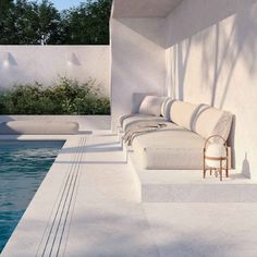 a white couch sitting next to a swimming pool