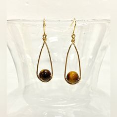 Imagine Wearing These Exquisite Handmade Tiger's Eye Wire-Wrapped Dangle Earrings, Each Bead Lovingly Encased In Shimmering Gold Tone Wire That Dances With Every Movement. The 9mm Genuine Tiger's Eye Beads, With Their Mesmerizing Golden-Brown Hues, Exude A Sense Of Warmth And Depth. The Handcrafted French Hook Ear Wires Ensure A Secure And Comfortable Fit, Allowing You To Wear These Earrings With Confidence All Day Long. Their Minimalist Design Adds A Touch Of Modern Elegance To Any Outfit, Whet Stud Wire Earrings, Brass Wire Jewelry, Diy Wire Wrapped Earrings, Fall Wire Wrapped Jewelry, Adjustable Hand Wrapped Dangle Earrings, Handmade Teardrop Wrap Earrings In Minimalist Style, Handmade Minimalist Teardrop Wrap Earrings, Hand Wrapped Drop Earrings, Hand Wrapped Adjustable Drop Earrings