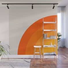 an orange and black wall mural in a living room with a ladder next to it