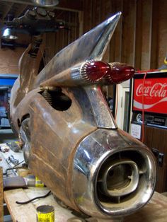 an old car is being worked on in a garage with tools and other items around it