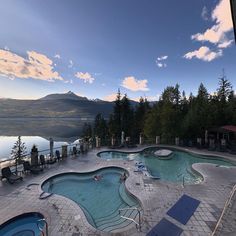 an outdoor swimming pool surrounded by lounge chairs