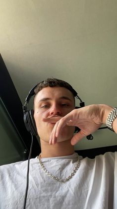 a young man wearing headphones making a funny face