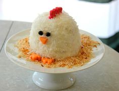 a white plate topped with rice and a chicken shaped cake on top of shredded cheese