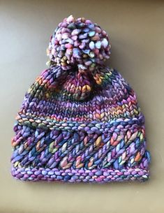 a multicolored knitted hat sitting on top of a table