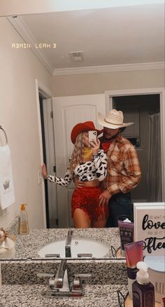 a man and woman standing in front of a bathroom mirror