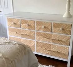 a white and wood dresser with drawers in a bedroom