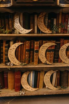 an old book shelf filled with books covered in paper crescents and handwritten letters