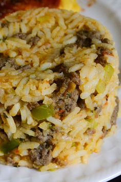 a close up of a plate of food with meat and rice on it, next to some sauce