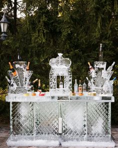 an ice bar with bottles and glasses on it in the middle of a brick patio