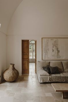 a living room filled with furniture and a large painting hanging on the wall above it