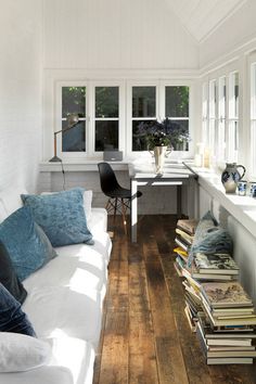 a living room filled with lots of furniture next to a white table and window sill